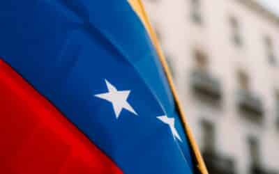 Close-up of the vibrant Venezuelan flag with stars in an urban environment, symbolizing national pride.