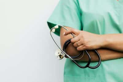 Close-up of a healthcare worker holding a stethoscope, showcasing medical professionalism.